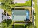 Aerial view of the home displaying its unique roof line, pool area, driveway, and fenced-in backyard at 1584 Silhouette Dr, Clermont, FL 34711