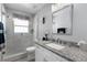 Bright bathroom with white vanity, granite countertop, updated fixtures, and glass enclosed shower at 1584 Silhouette Dr, Clermont, FL 34711