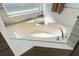 Close up of a soaking tub with modern tile and stylish fixtures beneath a window at 1584 Silhouette Dr, Clermont, FL 34711