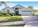 Charming home with a well-manicured lawn, mature landscaping, and an attached two-car garage at 1584 Silhouette Dr, Clermont, FL 34711