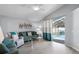 Inviting living room with vaulted ceilings, light gray walls, luxury vinyl plank flooring, and glass sliding doors to the lanai at 1584 Silhouette Dr, Clermont, FL 34711