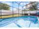 Backyard view features a screened-in pool and fenced green lawn at 1584 Silhouette Dr, Clermont, FL 34711