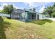 Exterior view of the screened-in pool and green backyard with a white fence and patio furniture at 1584 Silhouette Dr, Clermont, FL 34711