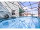 Back of the house with screened-in pool, fenced yard, and outdoor seating area at 1584 Silhouette Dr, Clermont, FL 34711