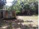 Spacious backyard featuring a weathered shed and a charming dog house amid mature trees at 2426 Maple Ave, Sanford, FL 32771