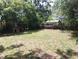 A large backyard with mature trees and a quaint dog house, perfect for outdoor enjoyment at 2426 Maple Ave, Sanford, FL 32771