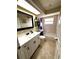 Updated bathroom with modern vanity, black hardware, decorative mirror, and tiled shower-tub combo at 2550 Sw Ivy Pl, Dunnellon, FL 34431