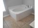 A large, white tiled bathtub provides a relaxing focal point in this bright bathroom at 3223 Sw 41St Ave, Ocala, FL 34474