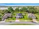 Aerial view of homes featuring mature trees, green lawns, and picturesque water views in a quiet neighborhood at 358 Irving Bend Dr, Groveland, FL 34736