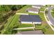 A backyard view showcasing solar panels, green lawn, privacy fence, and home's architectural details at 358 Irving Bend Dr, Groveland, FL 34736