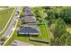 A backyard view showcasing solar panels, green lawn, privacy fence, and home's architectural details at 358 Irving Bend Dr, Groveland, FL 34736