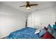 Bright bedroom features a ceiling fan, closet, and a comfortable bed with blue bedding at 358 Irving Bend Dr, Groveland, FL 34736