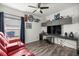 Well-decorated room featuring a red recliner, hardwood floors, built-in shelving, and a ceiling fan at 358 Irving Bend Dr, Groveland, FL 34736