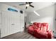 Cozy bonus bedroom features a red recliner, closet, ceiling fan, and hardwood flooring at 358 Irving Bend Dr, Groveland, FL 34736