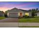 Charming single-story home with a brick driveway, manicured lawn, and a decorative wreath on the front door at 358 Irving Bend Dr, Groveland, FL 34736