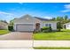 Charming single-story home with a brick driveway, manicured lawn, and a decorative wreath on the front door at 358 Irving Bend Dr, Groveland, FL 34736