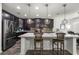 Open-concept kitchen featuring dark wood cabinetry, stainless steel appliances, and a spacious center island at 358 Irving Bend Dr, Groveland, FL 34736