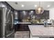 Stylish kitchen with dark cabinets, stainless steel appliances, granite countertops, and a decorative backsplash at 358 Irving Bend Dr, Groveland, FL 34736