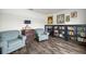 Cozy living room with two armchairs, decorative wood dresser and bookcase at 358 Irving Bend Dr, Groveland, FL 34736