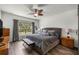 Comfortable main bedroom with a ceiling fan, large window, and hardwood floors at 358 Irving Bend Dr, Groveland, FL 34736