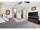 Main bedroom featuring a ceiling fan, a television with a fireplace, and ensuite bathroom access at 4232 Nw 56Th Ct, Ocala, FL 34482