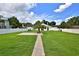 Beautiful backyard with green lawn, brick pathway, a palm tree, and a white perimeter fence at 5845 Sw 43Rd Street Rd, Ocala, FL 34474