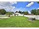 Lush, green backyard with a white fence, shed, and mature trees, perfect for outdoor activities at 5845 Sw 43Rd Street Rd, Ocala, FL 34474