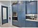 Modern kitchen with blue cabinets, stainless steel built-in microwave, oven, coffee bar, and doorway at 5845 Sw 43Rd Street Rd, Ocala, FL 34474