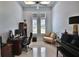 Home office boasts natural light, a desk area, a comfortable sofa, and a sleek grand piano at 5845 Sw 43Rd Street Rd, Ocala, FL 34474
