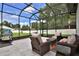 Relaxing screened patio featuring cushioned seating, coffee tables, and vibrant outdoor rug at 5845 Sw 43Rd Street Rd, Ocala, FL 34474