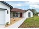 Beautiful single-story home featuring a red front door and stone accents with a well manicured lawn at 6240 Cherry Rd, Ocala, FL 34472