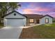 Charming single-story home featuring a red front door, stone accents and an attached two-car garage at 6240 Cherry Rd, Ocala, FL 34472