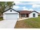 Charming single-story home with a two-car garage, stone accents, and a red front door at 6240 Cherry Rd, Ocala, FL 34472