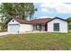 Charming single-story home featuring a red front door, stone accents and an attached two-car garage at 6240 Cherry Rd, Ocala, FL 34472