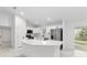 A modern white kitchen features stainless steel appliances, an island, and an open layout at 6240 Cherry Rd, Ocala, FL 34472