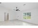Large open room with marble-look tile floors, ceiling fan and a white door at 6240 Cherry Rd, Ocala, FL 34472