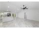 Open-concept living space with marble-look tile floors, ceiling fan, and bright white kitchen at 6240 Cherry Rd, Ocala, FL 34472