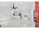 Open-concept living space with marble-look tile floors, ceiling fan, and bright white kitchen at 6240 Cherry Rd, Ocala, FL 34472
