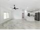 Open-concept living space with marble-look tile floors, ceiling fan, and bright white kitchen at 6240 Cherry Rd, Ocala, FL 34472
