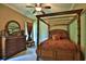 Cozy bedroom featuring a four-poster bed, wood furniture, and a ceiling fan for added comfort at 695 Se 47Th Loop, Ocala, FL 34480