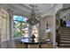 Charming dining area featuring a modern chandelier, neutral palette, and natural light from the large window at 695 Se 47Th Loop, Ocala, FL 34480