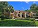 Stunning Mediterranean-style home featuring a tile roof, lush landscaping, and a welcoming front entrance at 695 Se 47Th Loop, Ocala, FL 34480