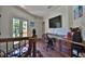 Upstairs hallway features hardwood floors, a built-in desk, and access to a balcony with French doors at 695 Se 47Th Loop, Ocala, FL 34480