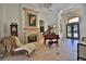 Elegant living room featuring a fireplace, a grand piano, and soaring ceilings with ornate chandeliers at 695 Se 47Th Loop, Ocala, FL 34480