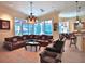 A well-lit living room includes comfortable seating, tile flooring, large windows, and seamless access to outdoor entertainment at 695 Se 47Th Loop, Ocala, FL 34480