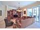 This spacious living room includes tile floors, a large entertainment center, and sliding glass doors to an outdoor patio at 695 Se 47Th Loop, Ocala, FL 34480