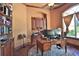 A sophisticated office boasts built-in shelving, a large window with natural light, and an elegant desk space at 695 Se 47Th Loop, Ocala, FL 34480