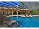 Spectacular screened-in pool with rock waterfall feature and connected sunroom for outdoor relaxation and entertainment at 695 Se 47Th Loop, Ocala, FL 34480
