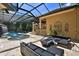 Screened-in backyard with outdoor kitchen and comfortable seating areas surrounding an inviting custom pool at 695 Se 47Th Loop, Ocala, FL 34480