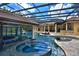 Expansive screened-in pool area featuring a grotto, spa, and outdoor bar for luxurious leisure at 695 Se 47Th Loop, Ocala, FL 34480